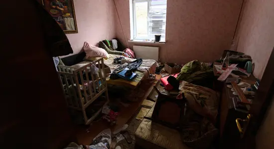 A bedroom that is full of clutter and other items.png