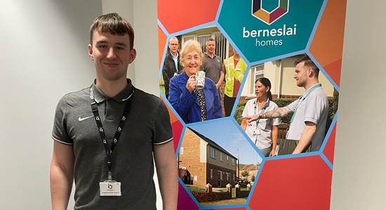 A smiling student stood in an office.
