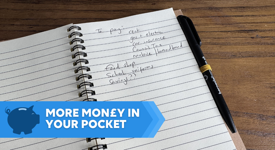 An open notebook with a handwritten list of bills to pay.