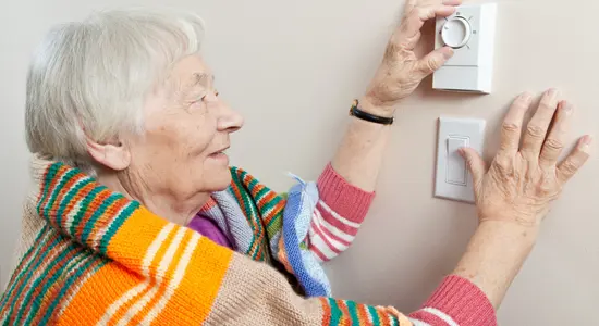 Resident adjusting the thermostat
