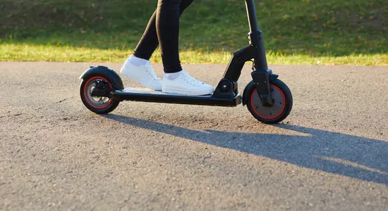 A person using an electric scooter on a path.png